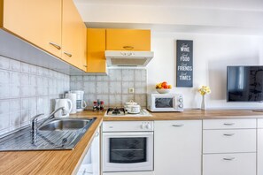 A modern kitchen with a gas stove, oven, microwave, and a coffee maker.