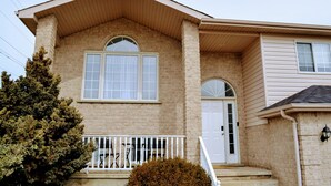 A two-story house with a front porch, a small staircase, and a garage.