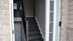 A staircase leading to a second floor, a door, and a mailbox on the exterior wall.