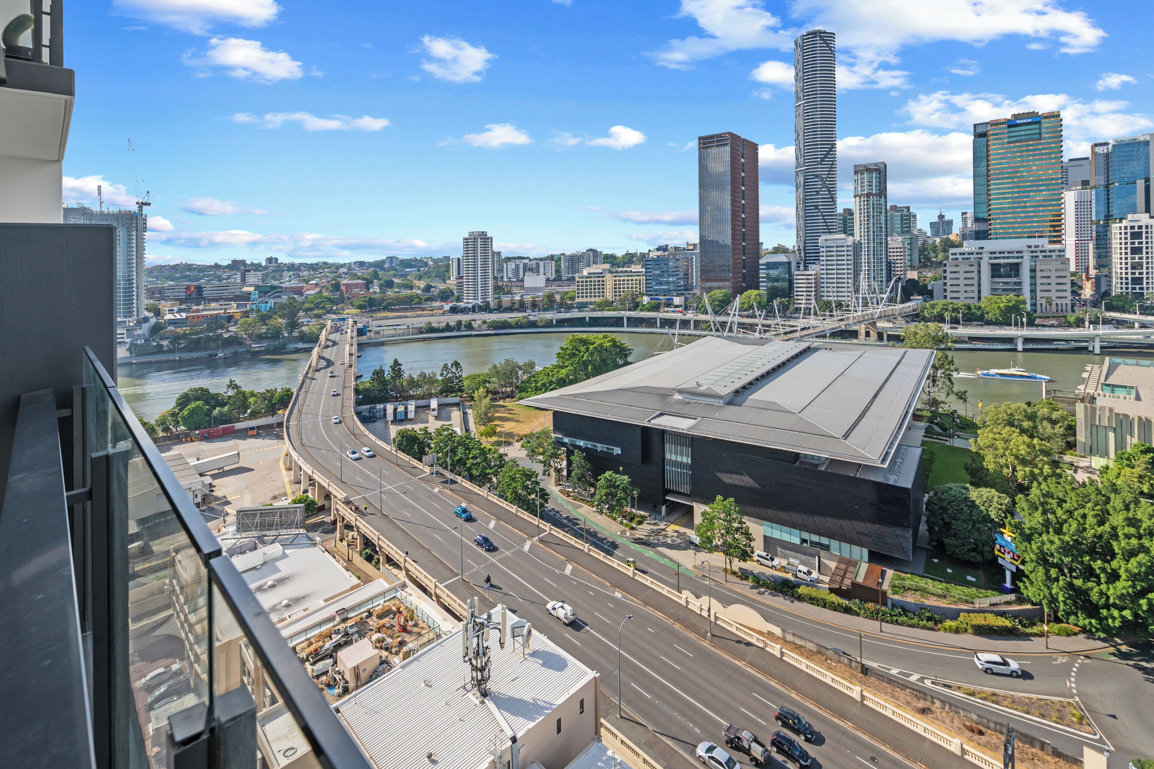 A cityscape with a river, modern buildings, and a bridge.