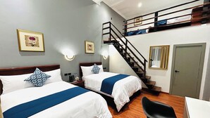 A hotel room with two beds, a desk, a chair, a staircase, and a door. - ACCEL Hotel Casa Nueva (Ibarra)