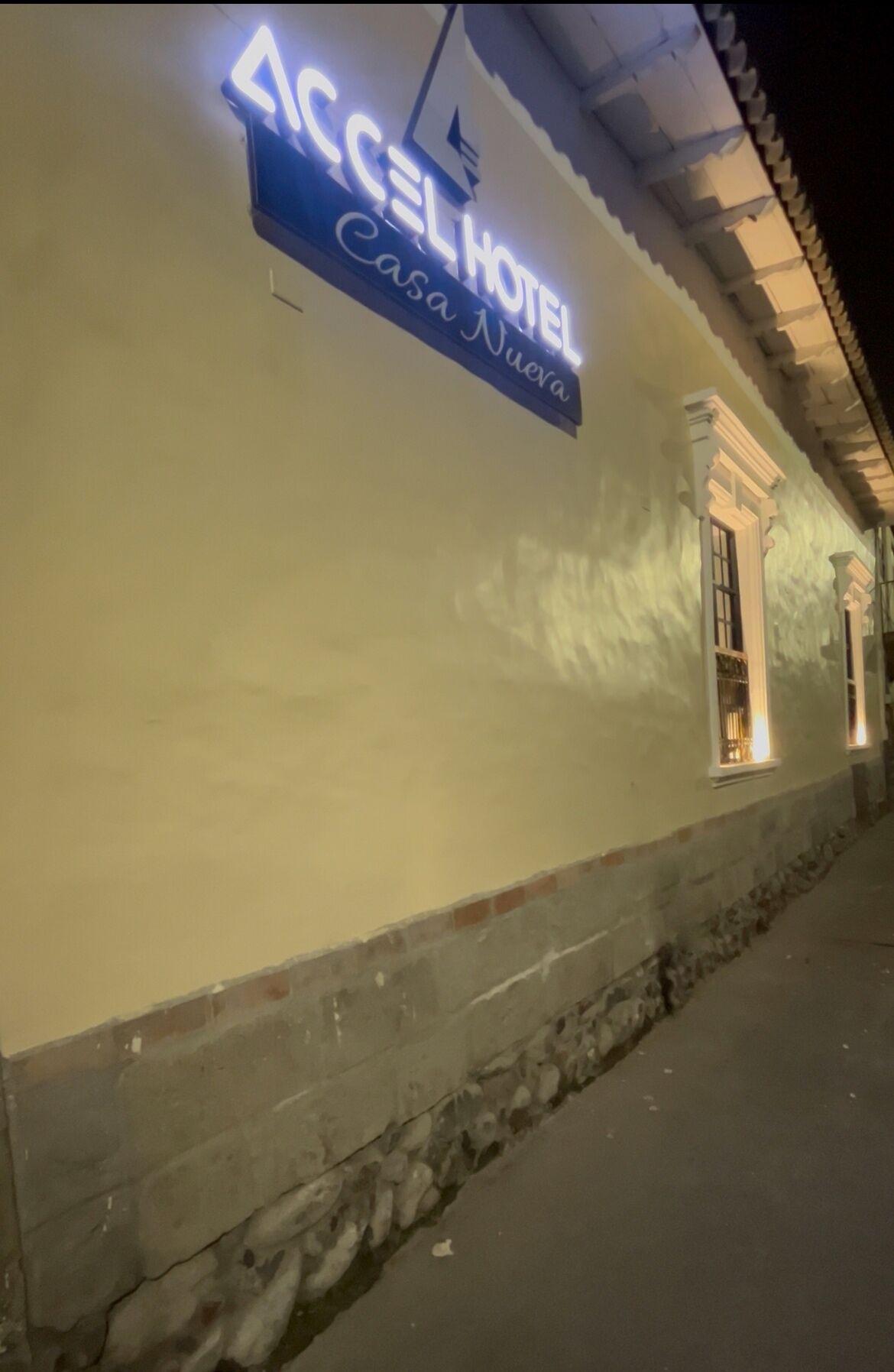A building with a sign reading "ACCEL HOTEL Casa Nueva."