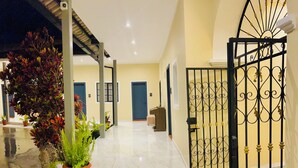 A hotel corridor with a gated entrance, potted plants, and a tiled floor. - ACCEL Hotel Casa Nueva (Ibarra)