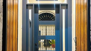 A blue door with a metal gate, a small window, and a decorative tile mat at the entrance. - ACCEL Hotel Casa Nueva (Ibarra)