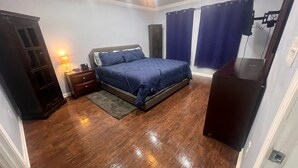 A bedroom with a bed, nightstand, dresser, and a desk. - Newly Renovated, Charming 3-bedroom, 2-bathroom house in Arabi (Arabi)