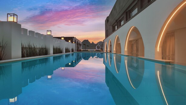 A pool with clear reflections, a sunset sky, and modern architecture with arched doorways. - SYYF Xiang Shan You Yue Jiudian Guilin (Guilin)