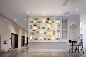 A modern hotel lobby with a marble floor, a wall-mounted light display, and a seating area with two chairs. - SYYF Xiang Shan You Yue Jiudian Guilin (Guilin)
