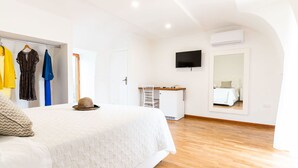 A bedroom with a bed, a desk, a TV, and a wardrobe. - Nice apartment for 4 people with A/C, pool, WIFI, hot tub, TV and patio (Massa Lubrense)