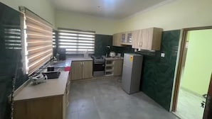 Une cuisine de taille réduite équipée d’une cuisinière à gaz, d’un évier et d’un réfrigérateur.