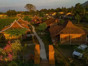 A traditional village with thatched-roof houses, a central pathway, and a parked car. - Balkondes Tuksongo (Borobudur)