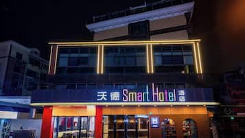 A hotel with a modern facade, multiple floors, and illuminated signage.