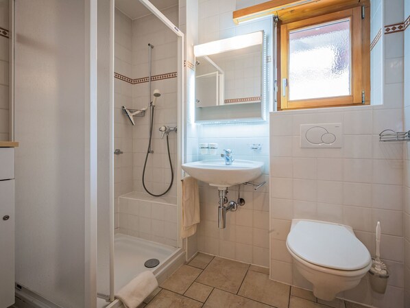A bathroom with a shower, sink, and toilet.