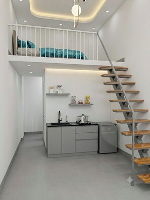 A compact kitchen with a built-in stove, a sink, and a compact refrigerator.