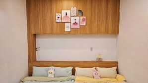 A bedroom with two beds, each with a wooden headboard and a wall-mounted shelf above. - Mit homestay (Hue)