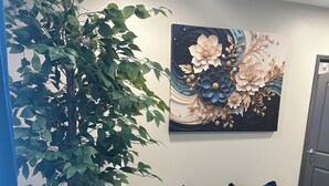 A modern living room with a beige sofa, a large potted plant, a blue and white rug, and a decorative wall piece. - Cozy and Clean 1 Bedroom Apt centrally located in Downtown Birmingham, Near UAB (Birmingham)