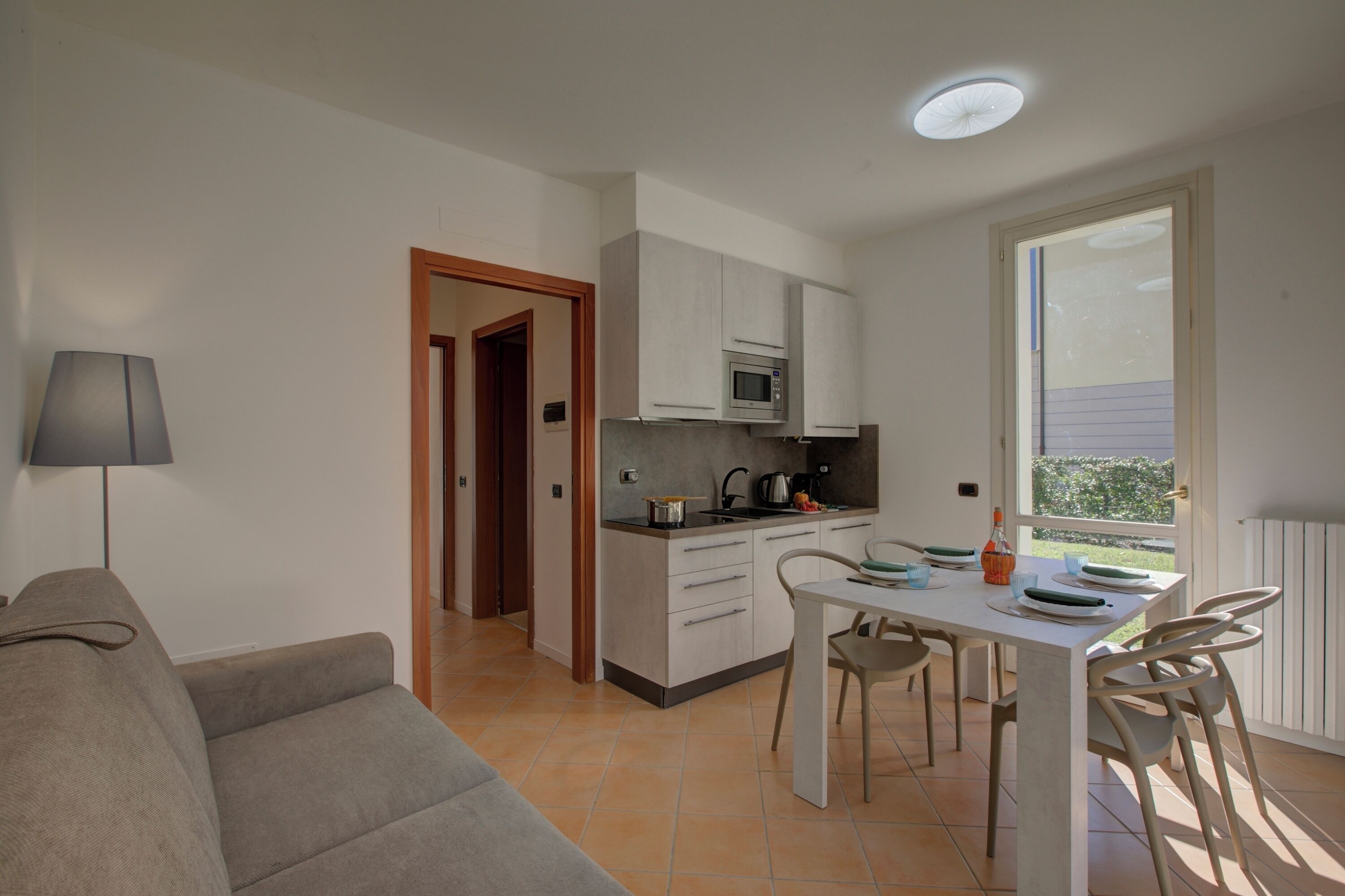 Un espacio habitable compacto con kitchenette, comedor y sofá.