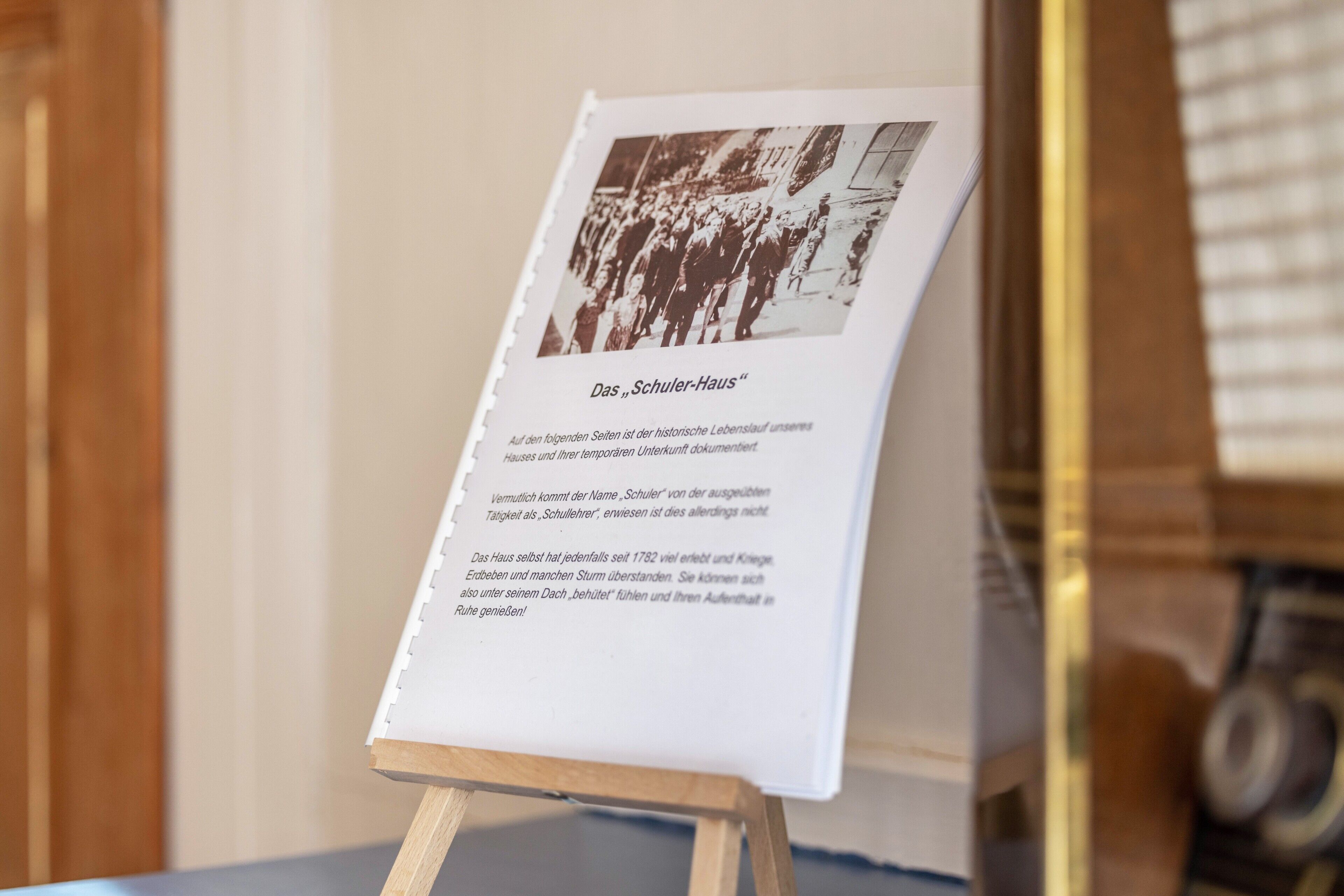 Historiallinen dokumentti, joka on esillä taulutelineessä, ja sen yhteydessä on valokuva ja teksti.