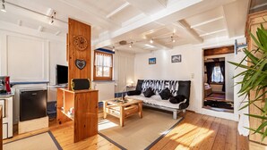 Una sala de estar con sofá, mesa de centro y aparador de madera.