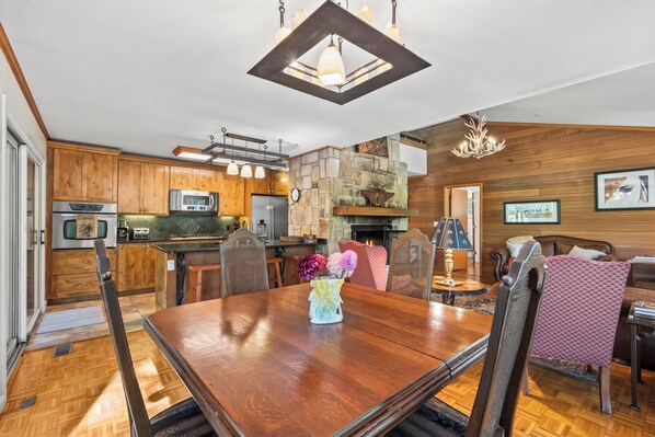 A modern kitchen with wooden cabinets, stainless steel appliances, and a stone fireplace.