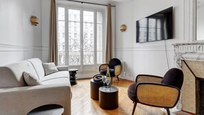 A modern living room with a sofa, chairs, a coffee table, and a fireplace. - TheBlueStay 318 - Apartment near the Eiffel Tower (Paris)