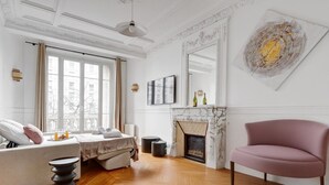 A modern living room with a fireplace, a sofa, a chair, and a large window. - TheBlueStay 318 - Apartment near the Eiffel Tower (Paris)