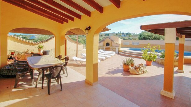 An outdoor patio with a table and chairs, a pool, and potted plants. - Finca Pineda - private pool villa in Benissa (Benissa)