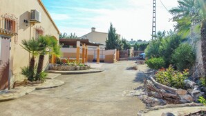 A residential street with a house featuring a covered porch, a garage, and a driveway. - Finca Pineda - private pool villa in Benissa (Benissa)