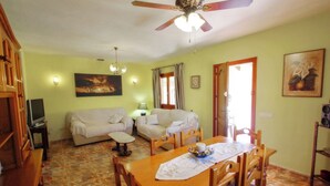 A living room with a sofa, a dining table, and a ceiling fan. - Finca Pineda - private pool villa in Benissa (Benissa)