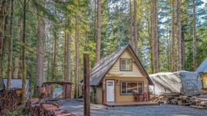 A cabin with a wooden exterior, a porch, and a gravel driveway. - Tee & Ski Cabin | Mt Rainier, White Pass (Packwood)