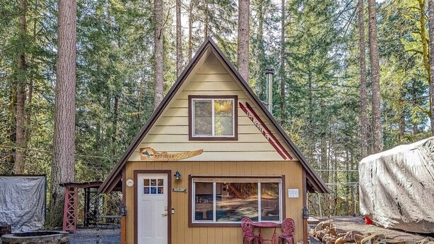 A small wooden cabin with a front porch, a window, and a sign that reads "DORCHER". - Tee & Ski Cabin | Mt Rainier, White Pass (Packwood)