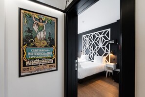 Une chambre d’hôtel comprenant un lit, une table de chevet et un panneau décoratif mural.