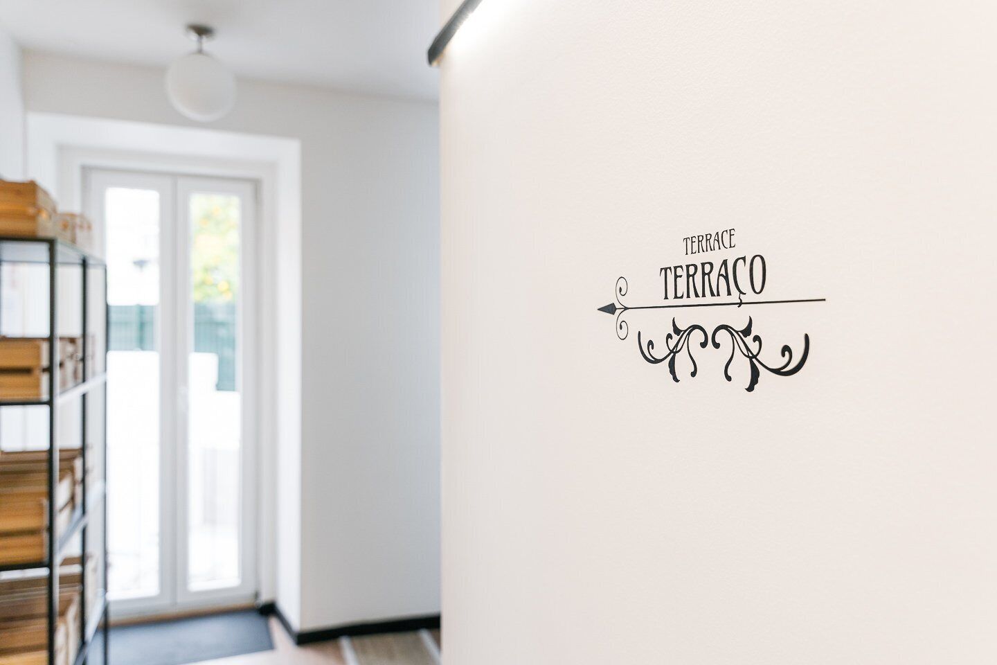 Ein Zimmer mit einer weißen Wand und einem dekorativen Schild mit der Aufschrift 'TERRACE'.
