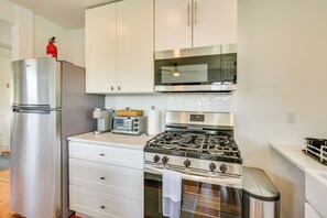 Une cuisine équipée d’un réfrigérateur en acier inoxydable, d’un four à micro-ondes, d’une cuisinière et d’un grille-pain.