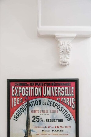 Une affiche encadrée faisant la publicité de l’Exposition universelle de 1889 à Paris, et offrant une réduction de 25 % sur les billets.