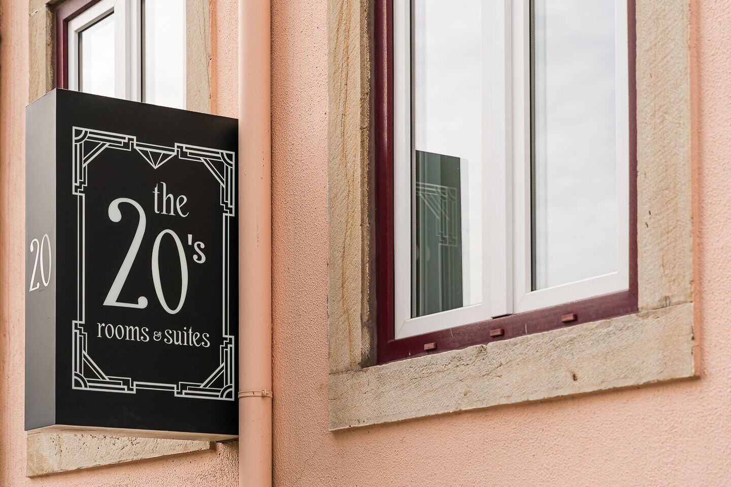 Une enseigne indiquant « The 20's rooms & suites » sur la façade d’un immeuble.