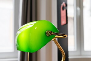 Een groene stoel met een metalen armleuning en een bolle rugleuning.