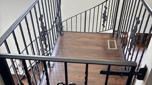 A wooden staircase with black metal railings and a decorative gate. - Movie Theater Retreat With Pickleball Court (Post Falls)