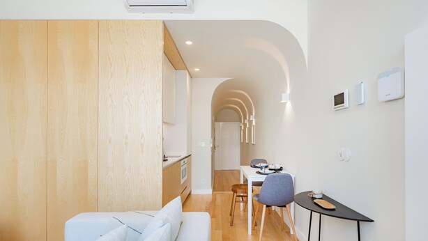 A modern, compact living space with a kitchenette, a dining area, and a seating area with a small table and chairs. - Casa da Música Modern Flat (Porto)