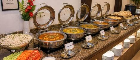 A buffet with various dishes and condiments.