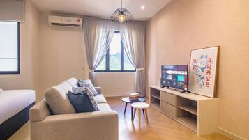 A modern living room with a sofa, a TV, and a small table.