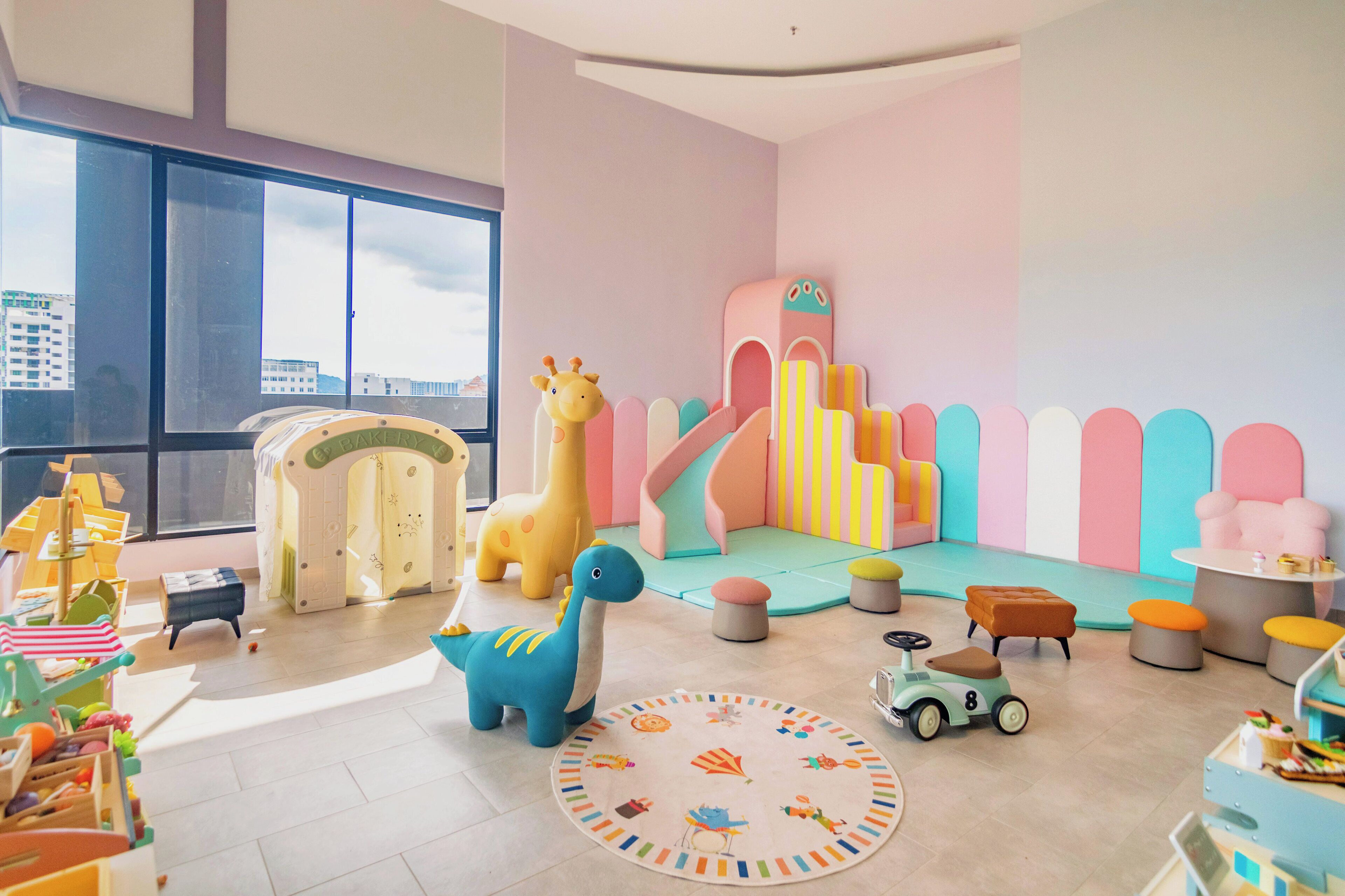 A brightly colored children's play area with a slide, a giraffe, and a dinosaur toy.