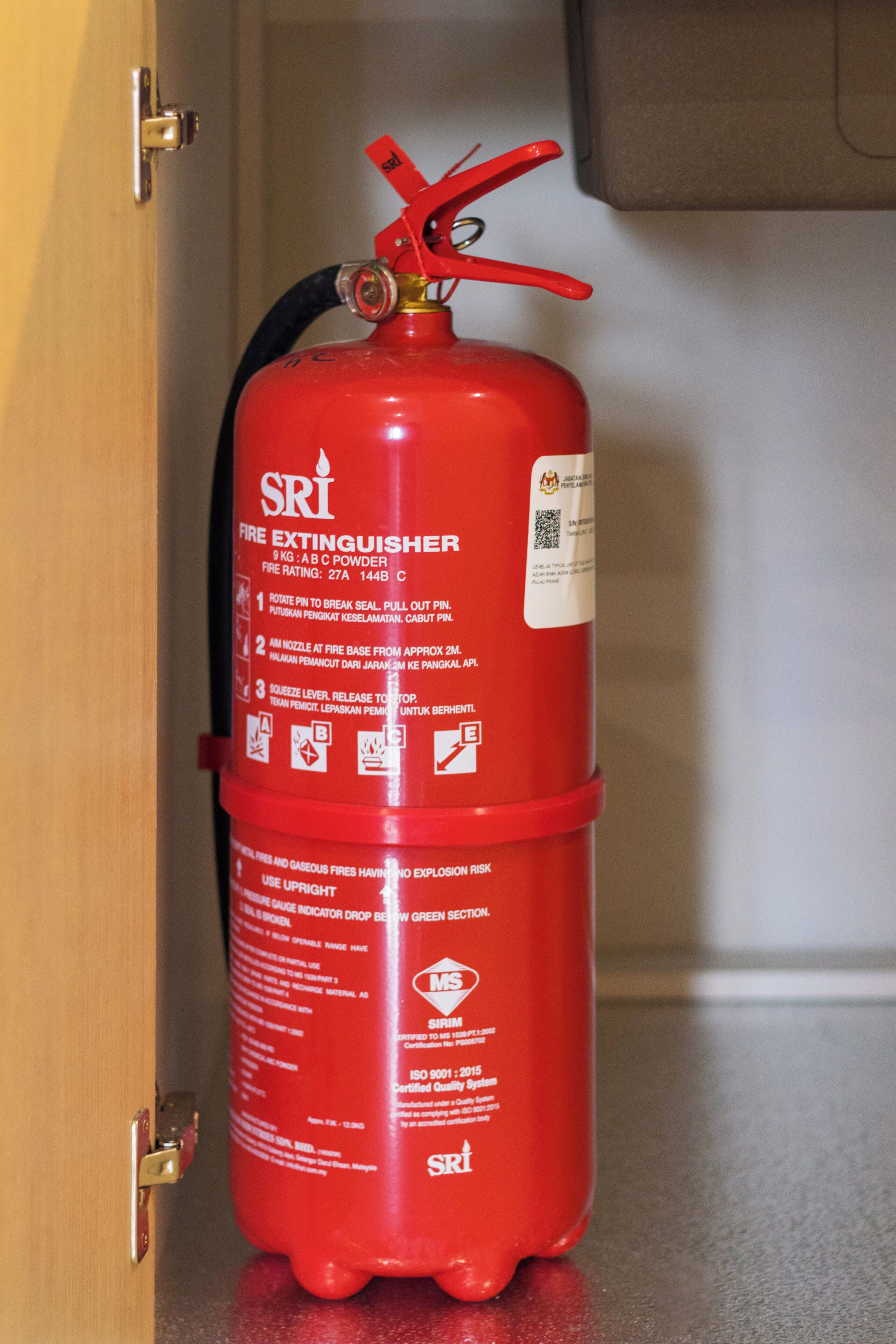 A red fire extinguisher mounted on a wall near a door.