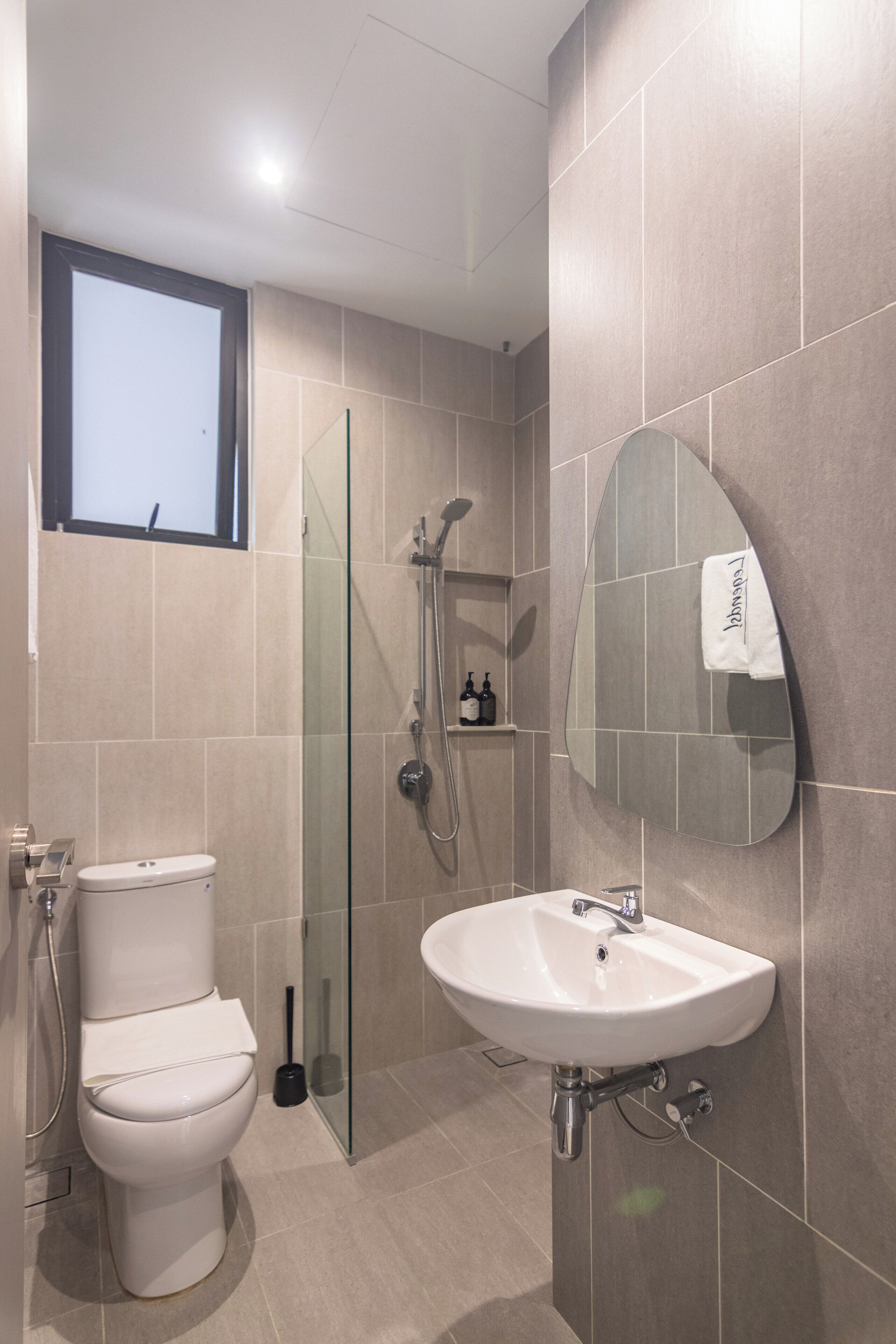 A modern bathroom with a toilet, sink, and shower.