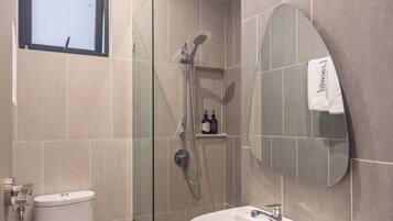 A modern bathroom with a toilet, sink, and shower.
