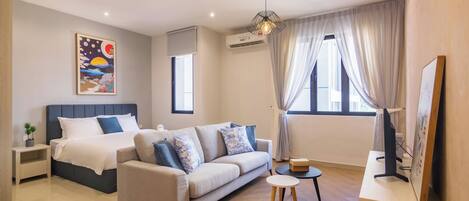 Une chambre d’hôtel moderne avec un lit, un canapé et une petite table.