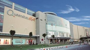 A large, modern building with the sign 'Queensbay Mall' prominently displayed.
