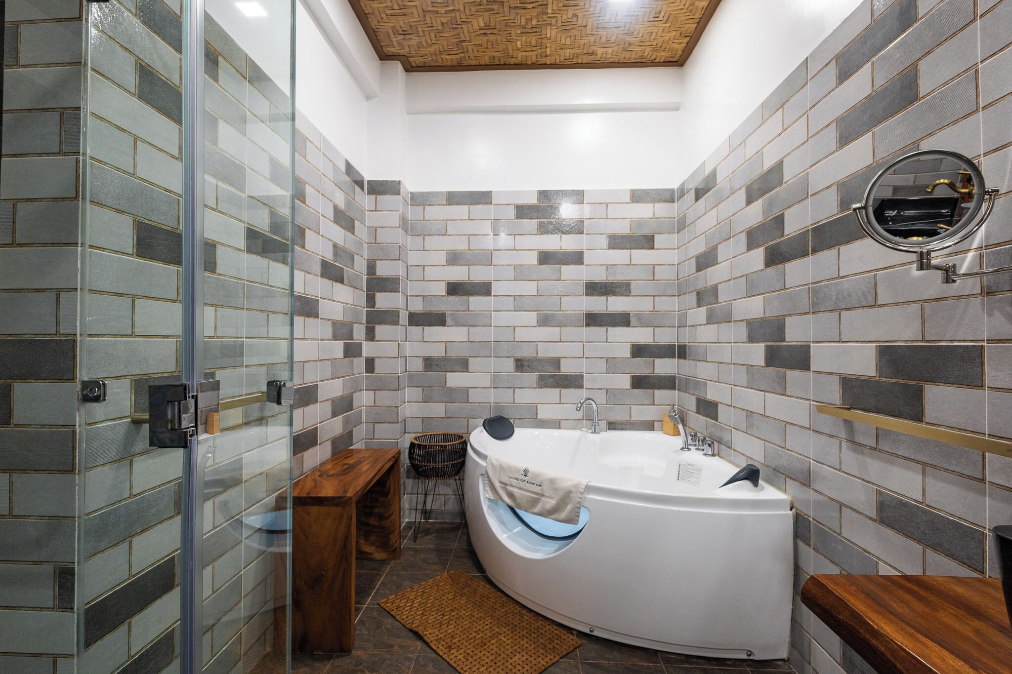 Une salle de bain moderne avec une douche à parois de verre, une baignoire sur pieds et un banc en bois.