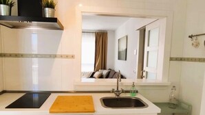 A compact kitchen with a countertop, sink, and a wooden cutting board. - Smart Conil los Bateles 28584 (Conil de la Frontera)
