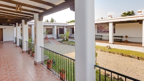 A covered outdoor area with a tiled floor, potted plants, and a gravel path. - Hacienda Puerto DE Conil 104 (Conil de la Frontera)