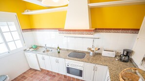 A kitchen with white cabinets, a granite countertop, a sink, a toaster, and a coffee maker. - Balc n Atl Ntico 27786 (Conil de la Frontera)